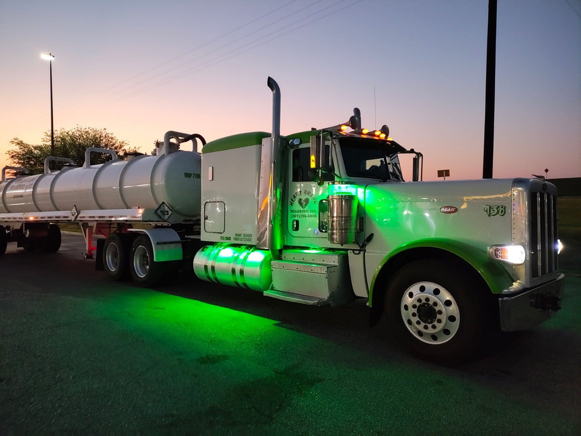 Heartbreak Trucking vacuum truck at sunset with green underglow
